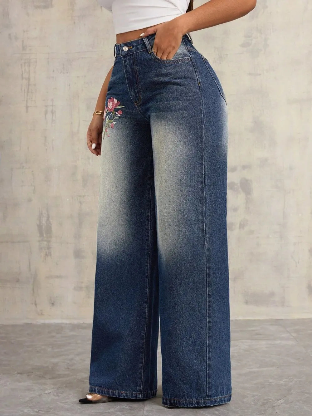 Delphine wide-leg jeans showing the button fly and fine embroidery along the leg