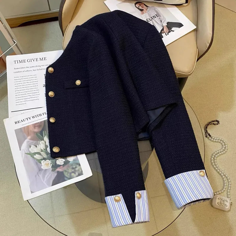 Clémence navy cropped jacket styled flat lay showing gold-tone buttons and striped cuffs