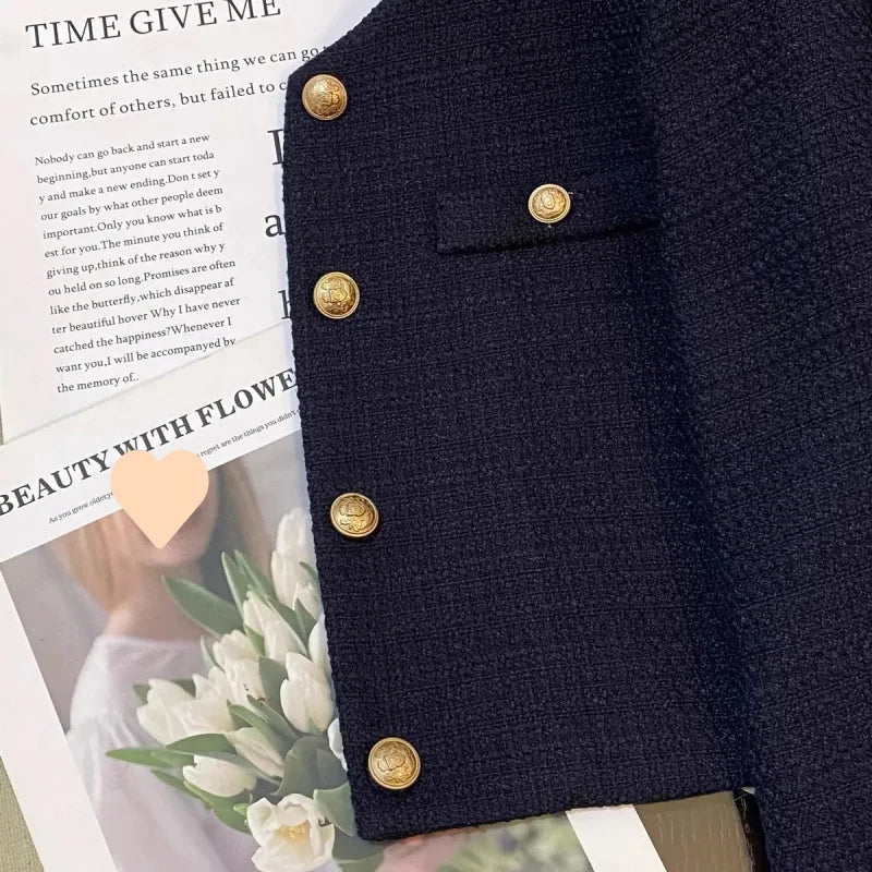 Close-up of gold-tone buttons and textured navy fabric on the Clémence jacket